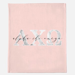 Puede incluir: Manta de franela rosa con un diseño de mármol blanco que presenta las letras griegas AXQ y el texto "alpha chi omega" en escritura cursiva negra.
