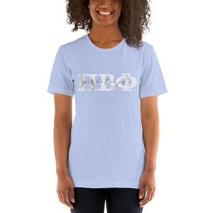 May include: A light blue t-shirt with a white marble design featuring the Greek letters "ΠΒΦ" and the words "pi beta phi" written in cursive.