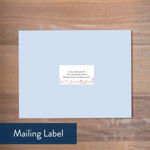 May include: A light blue mailing label with a white address label. The address reads: Alpha Omicron Pi, 800 Lakeshore Drive, Birmingham, Alabama 35229. The label is decorated with a pink and white floral border.