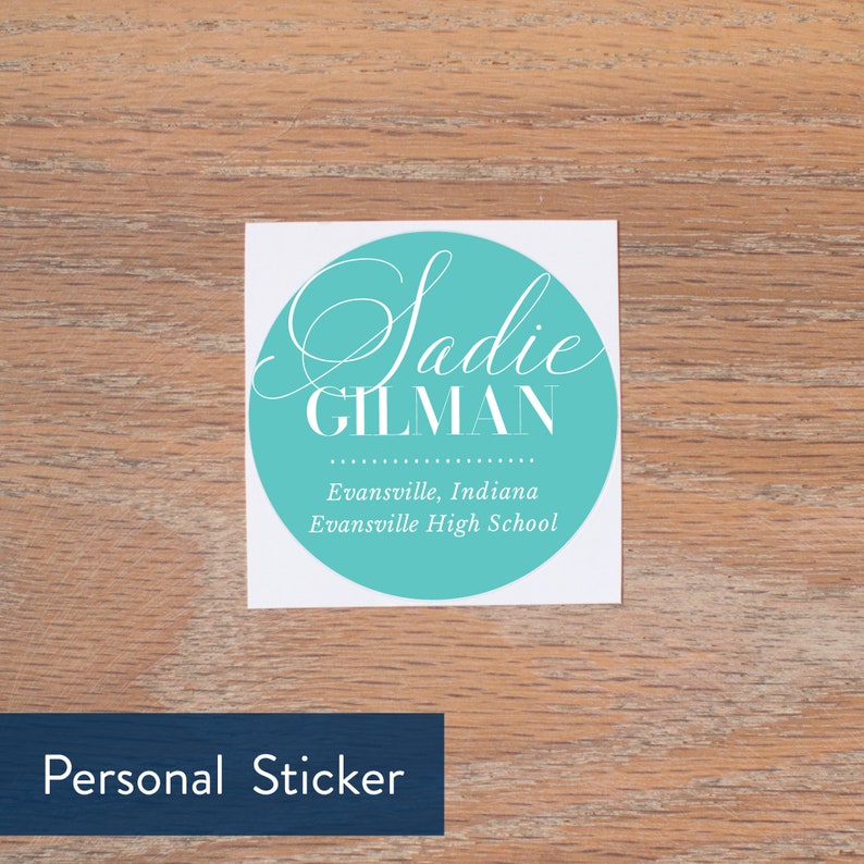 Może przedstawiać: Okrągła naklejka w kolorze turkusowym z białym tekstem, kt&oacute;ry brzmi "Sadie GILMAN" i "Evansville, Indiana Evansville High School". Naklejka znajduje się na drewnianej powierzchni.