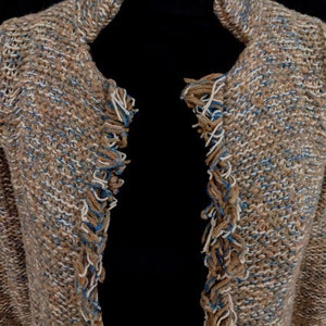 May include: A brown and blue knitted cardigan with fringe detailing on the edges.