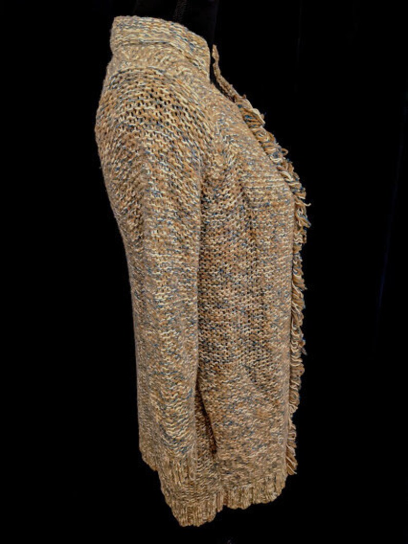 May include: A brown and blue knitted cardigan with a fringed hem. The cardigan is made of a soft, textured yarn.