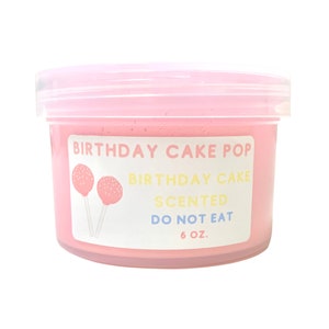 May include: A pink plastic container of slime with a white label that reads "Birthday Cake Pop Birthday Cake Scented Do Not Eat 6 oz.". The label also features two cartoon cake pops with white sprinkles.