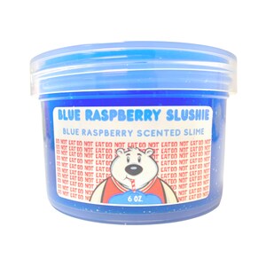May include: A blue plastic container of blue raspberry scented slime with a polar bear wearing a red and white jersey holding a blue and white straw. The container has the text "BLUE RASPBERRY SLUSHIE" and "BLUE RASPBERRY SCENTED SLIME" printed on it. The container is 6 oz.