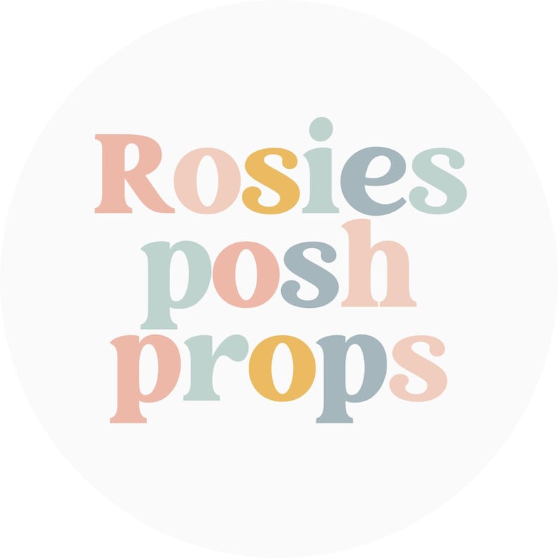 May include: A circular logo featuring the text "Rosies posh props". The text is in a whimsical font, using a palette of pastel colours: peach, yellow, blue and grey, on a white background.
