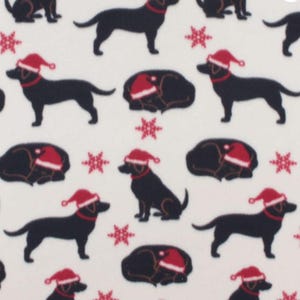 May include: White fabric with a repeating pattern of black dachshund dogs wearing red Santa hats and collars, interspersed with red snowflakes. The dogs are in various poses, some standing, some lying down.