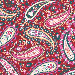Pode incluir: Um tecido vermelho com um padrão paisley em tons de rosa, verde e branco. O padrão paisley é repetido em todo o tecido.