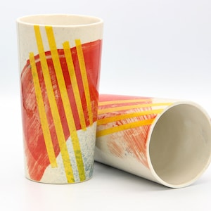 Weiß orange gelb gestreifte Keramikbecher mit handgemalten Designs, gestreifter zeitgenössischer Graffitibecher, hohe Tasse der abstrakten Malerei