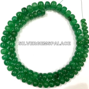 Könnte beinhalten: Eine Kette aus grünen Edelsteinperlen, wahrscheinlich Smaragde, mit runder, facettierter Form. Die Perlen sind auf einem dünnen Draht aufgefädelt und zu einem Kreis angeordnet. Das Bild enthält den Text "SILVERGEMSPALACE".