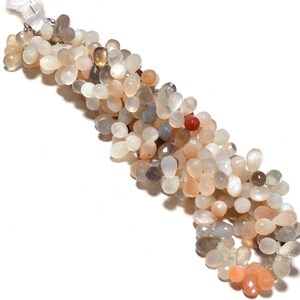 May include: A strand of light gray, peach, and white moonstone beads. The beads are teardrop shaped and have a pearlescent sheen.