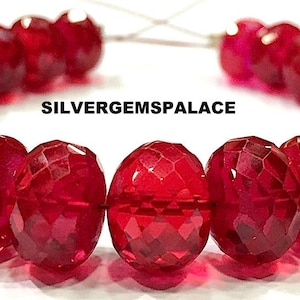 May include: A strand of deep red faceted gemstone beads. The beads are round and have a smooth, polished finish. The beads are strung on a clear thread and are ready to be used for jewelry making.