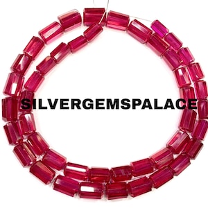 May include: Strands of faceted, rectangular ruby-colored beads. The beads are strung together, forming a curved shape against a white background. The text "SILVERGEMSPALACE" is printed across the image.