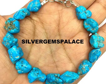 Può includere: Un braccialetto turchese con perline irregolari a forma di pepita. Le pietre blu brillante sono infilate con una chiusura color argento. Il testo "SILVERGEMSPALACE" è stampato sull'immagine.
