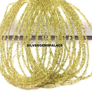 Puede incluir: Múltiples hebras de pequeñas piedras preciosas de color amarillo pálido de forma irregular. Las cuentas están ensartadas, creando múltiples líneas del mismo material. El texto "SILVERGEMSPALACE" es visible.