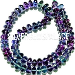 May include: A strand of purple and blue gemstone beads. The beads are oval shaped and have a smooth, polished finish.