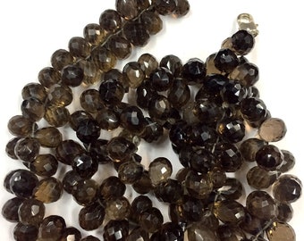 May include: A strand of dark brown faceted gemstone beads. The beads are strung on a silver wire and have a clasp.