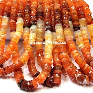 May include: A strand of orange, red and white gemstone beads. The beads are faceted and have a natural, irregular shape. The beads are strung on a clear thread.