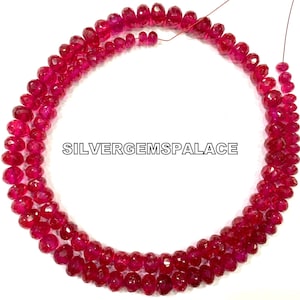 May include: A strand of ruby red faceted gemstone beads. The beads are strung on a wire and are approximately 6mm in diameter. The beads are arranged in a circular pattern and are displayed on a white background. The text "SILVERGEMSPALACE" is visible in the center of the image.