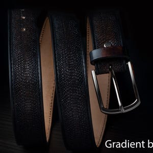 Könnte beinhalten: Ein schwarzer Gürtel mit strukturierter Oberfläche und silberner Schnalle. Der Gürtel besteht aus dunklem Material und hat einen Farbverlauf. Der Text "Gradient black" ist unten im Bild zu sehen.