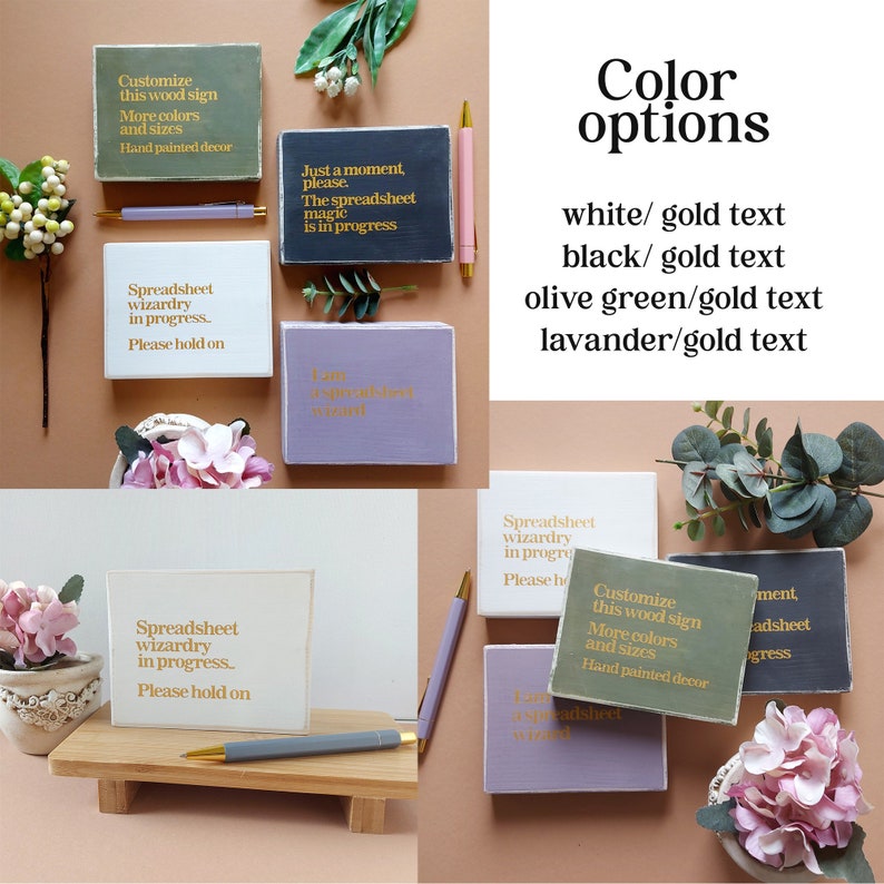 May include: Six wooden signs with different colored backgrounds and gold text. The signs say "Spreadsheet wizardry in progress. Please hold on."  The signs are on a light brown background with flowers and greenery.