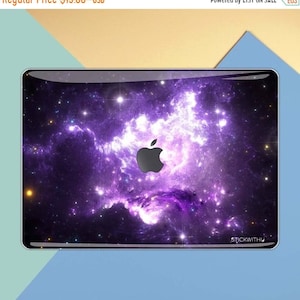 May include: A purple and black galaxy-themed laptop skin with a white apple logo in the center. The skin has a glossy finish and is designed to fit a MacBook.