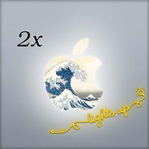 May include: An illuminated apple-shaped design featuring a Japanese wave print. The design includes the text "lights up" in yellow, with a matching yellow cord and plug. The number "2x" is in the upper left corner.