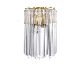 May include: A gold-toned wall sconce with clear glass crystals hanging from the fixture. The crystals are arranged in a circular pattern around the light source.