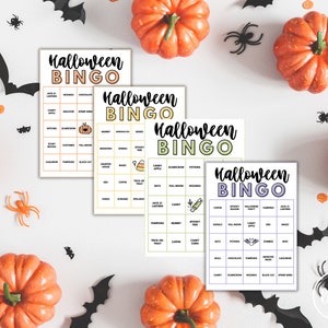 May include: Four Halloween Bingo cards with different color schemes, featuring words like "Jack-O-Lantern" and "Candy Apple." The cards are surrounded by orange pumpkins, black bats, and spiders, creating a festive holiday theme.