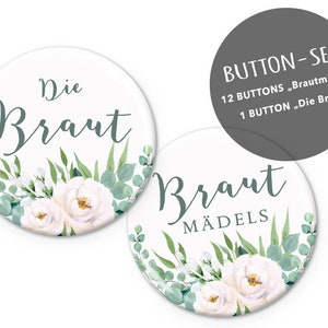 Könnte beinhalten: Ein Set mit 13 runden weißen Knöpfen mit Blumenmotiven. Ein Knopf sagt "Die Braut" und der andere sagt "Braut Mädels".