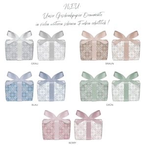 May include: Gift wrapping paper with a decorative pattern in various colors, including gray, brown, blue, green, and pink. The text "NEU: Unser Geschenkpapier Ornamente in vielen weiteren sch&ouml;nen Farben erh&auml;ltlich!" is displayed above the paper.