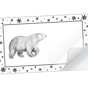 Könnte beinhalten: Eine Schwarzweißillustration eines Eisbären in einem Rahmen mit einem Schneeflockenrand.