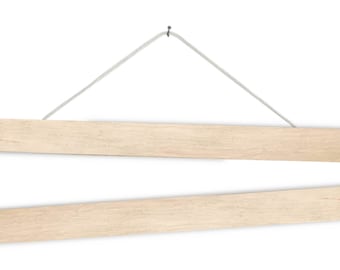 Könnte beinhalten: Ein Satz aus zwei magnetischen Posterhaltern aus Holz, jeder 51 cm lang. Die Halter sind an einer weißen Schnur aufgehängt und haben eine natürliche Holzoptik.