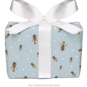 Könnte beinhalten: Eine hellblaue Geschenkbox mit einem weißen Band und einem Muster aus Bienen und weißen Punkten. Der Text "Nur Dekorationsbeispiel KEINE Schleife in Lieferung vorhanden" ist auf der Unterseite der Box aufgedruckt.