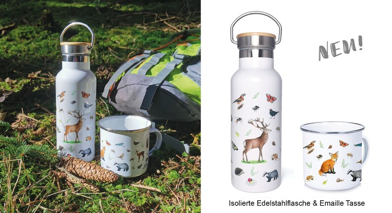 May include: A white insulated stainless steel water bottle and a white enamel mug with a forest animal design. The bottle has a bamboo lid and a carrying handle. The mug has a black rim and handle. The text "NEW!" is in the upper right corner of the image. The text "Isolierte Edelstahlflasche & Emaille Tasse" is at the bottom of the image.