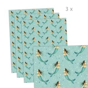 May include: A set of three turquoise blue wrapping paper sheets with a repeating pattern of mermaids with green tails and white shells. The mermaids are swimming in a sea of white bubbles.