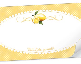 Può includere: Un adesivo giallo e bianco con un design a limone e il testo "Mit Liebe gemacht". L'adesivo ha uno sfondo a pois e un bordo a festoni.
