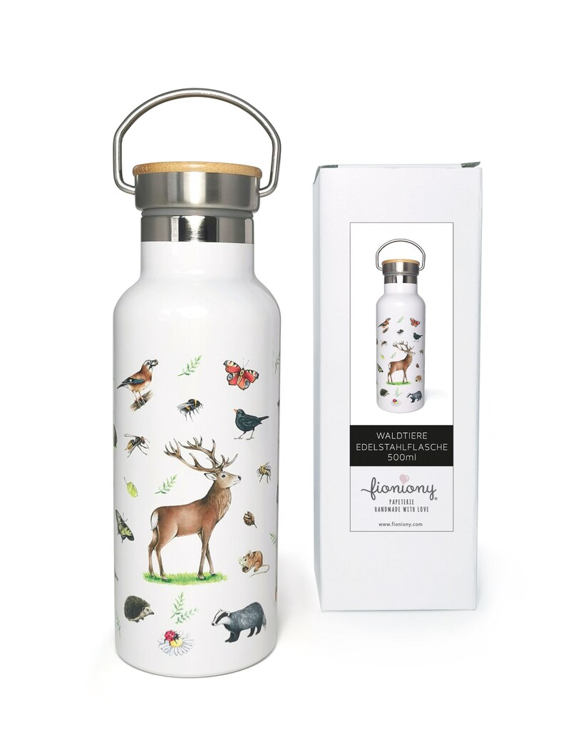 May include: White stainless steel water bottle with a bamboo lid and a carrying handle. The bottle features a colorful illustration of forest animals, including a deer, birds, butterflies, and insects. The bottle is 500ml and is packaged in a white box with the text "Waldtiere Edelstahiflasche 500ml" and the brand name "fioniony".