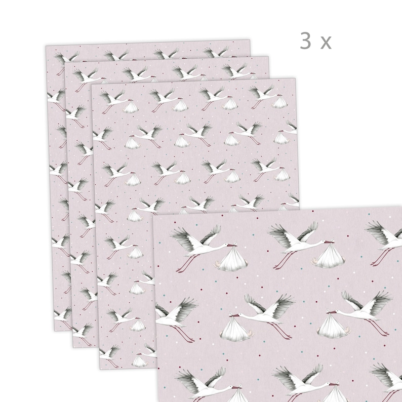 K&ouml;nnte beinhalten: Drei Bl&auml;tter rosa Geschenkpapier mit einem wei&szlig;en Storchenmuster, das ein Babyb&uuml;ndel tr&auml;gt. Das Papier hat ein dezentes wei&szlig;es Punkte-Muster.