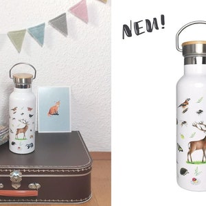 Pu&ograve; includere: Bottiglia d'acqua in acciaio inossidabile isolata di colore bianco con tappo in bamb&ugrave; e maniglia per il trasporto. La bottiglia presenta un design colorato di animali della foresta, tra cui un cervo, uccelli e un tasso. Il testo "NEW!" &egrave; visibile sullo sfondo. La bottiglia ha una capacit&agrave; di 500 ml.