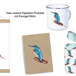 Pu&ograve; includere: Un set di articoli di cancelleria con un'illustrazione ad acquerello di un martin pescatore appollaiato su un giunco. Il set include una stampa incorniciata, un quaderno, una tazza, carta da regalo e un biglietto d'auguri. I prodotti sono tutti marroni e bianchi con accenti blu.