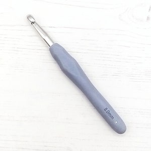 May include: A gray crochet hook with a silver hook and a 8.0mm size label.