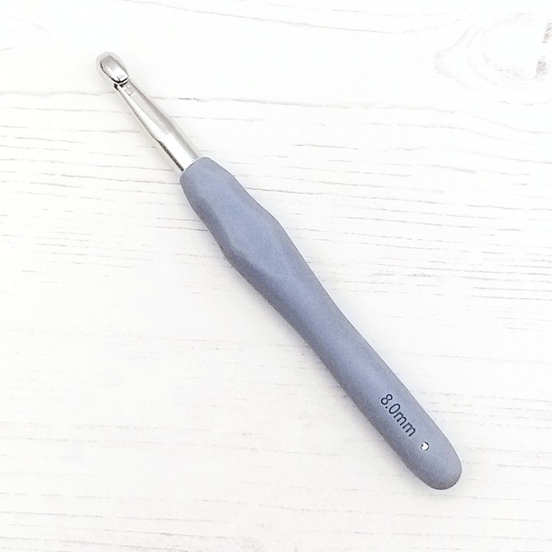 May include: A gray crochet hook with a silver hook and a 8.0mm size label.
