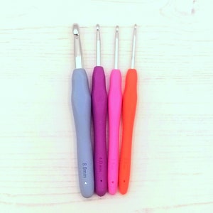 May include: Four crochet hooks with colorful handles. The hooks are 8.0 mm, 4.0 mm, 3.5 mm, and 3.0 mm.