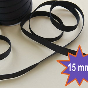 May include: Black elastic ribbon, 15 mm wide, wound on a spool. The ribbon is shown in a close-up view, with a portion of the ribbon lying on a white surface.