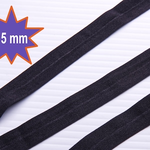 May include: Two black elastic bands, each 15 mm wide, are laid out on a white surface. The bands are flat and have a smooth texture.