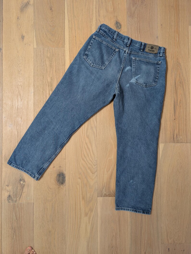 Op de afbeelding: Blauwe denim jeans met een klassiek ontwerp met vijf zakken. De jeans hebben een rechte pijp en een vervaagde wassing. Een bruine leren patch met de merknaam is zichtbaar op de achterste tailleband.