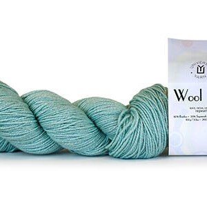 May include: A skein of teal blue Wool Pop yarn by Universal Yarn. The label reads "Wool Pop" with the yarn content: 80% Superwash Wool, 20% Silk. The yarn is 100 grams, 350 yards.