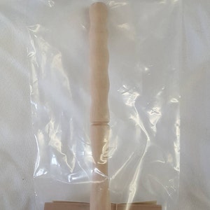 May include: A wooden flick carder for spinning wool, packaged in a clear plastic bag with a brown paper label that reads "Ashford Wheels & Looms" and "Flick Carder $26.50".