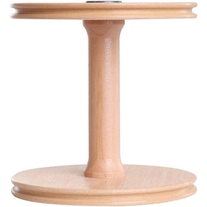 May include: A wooden yarn swift with a round base and a center spindle. The swift is made of light brown wood and has a smooth finish.