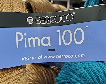 May include: A close-up of two skeins of yarn, one brown and one teal blue. The label reads "Berroco Pima 100" and "Visit us at www.berroco.com".
